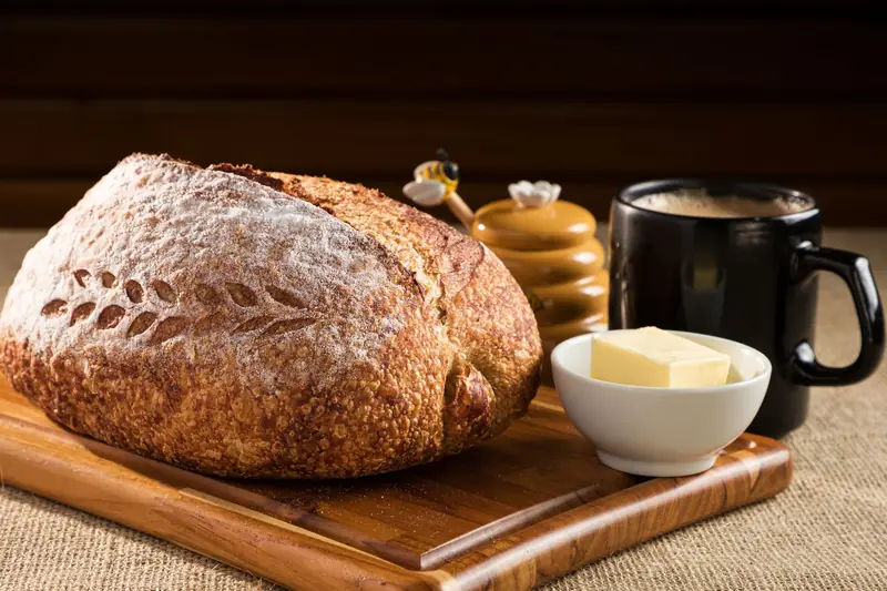 Freshly baked sourdough with butter and coffee on a wooden tray in Santa Maria, Brazil