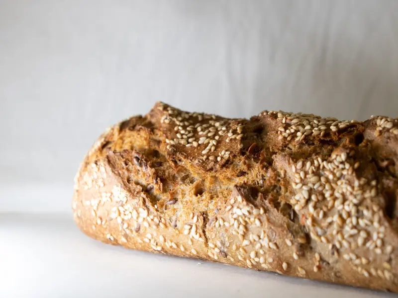 Freshly baked homemade bread loaf with sesame seeds, highlighting texture and crust