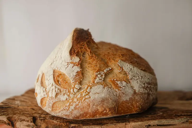 Close-up of freshly baked artisan sourdough bread on a rustic wooden board