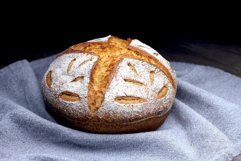 Close-up of freshly baked artisan sourdough bread on a grey linen cloth