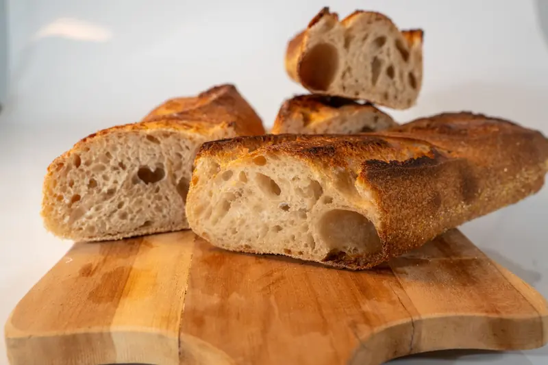 Close-up of freshly baked artisanal bread slices on a wooden board