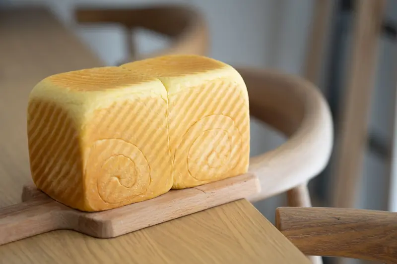 Close-up of a freshly baked artisan bread loaf on a wooden board, showcasing texture and detail