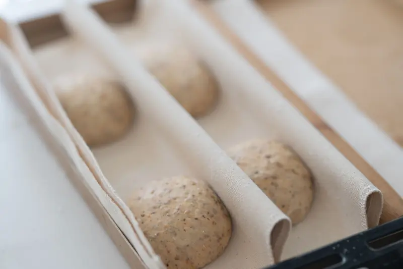 Close-up of artisanal sourdough bread dough proofing in a wooden box, ready for baking
